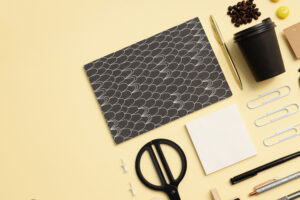 A cohesive flat lay — including stationary, pens, coffee beans, and a disposable cup — illustrating the basics of branding for small businesses.