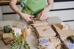 Entrepreneur in a green apron packaging artisanal soap in eco-friendly materials, showcasing small business quality and sustainability.