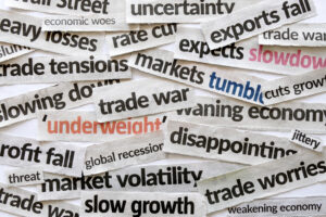 Mixed newspaper headlines about economic issues like market volatility, trade tensions, tariffs and inflation.
