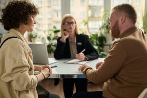 Two professionals in a bright office discussing a small business buy-sell agreement with their attorney.