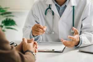 A doctor in a white coat with a stethoscope discusses healthcare options with a patient during a consultation. The scene, set in a professional office, symbolizes collaboration and care, aligning with the goals of small business healthcare reform.