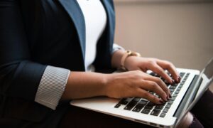 A professional researches affordable ERP implementation services on a silver laptop.