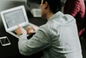 Small business team reviewing AI contract software on a laptop in a collaborative workspace.